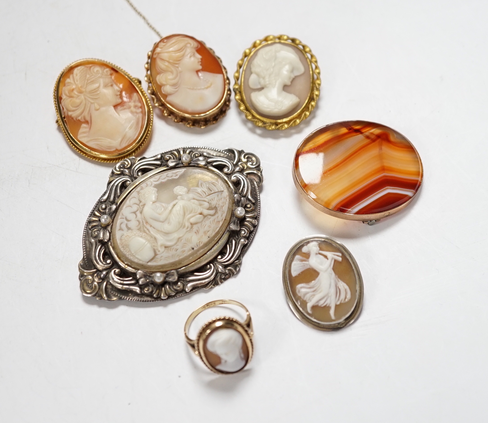 Two modern 9ct gold mounted oval cameo shell brooches, a 9ct gold and cameo shell set ring, three other cameo shell set brooches and a 9ct and banded agate set oval brooch, 40mm.